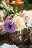Silver vase of roses on tea-time buffet