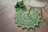 Crocheted lime-green doily-style rug on rustic wooden floor