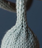 A knitted cable holder for a light bulb (close-up)