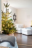 Lights on Christmas tree in living room with Star of David on wall