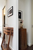 Custom walnut console table below framed picture and Madonna figurine on wooden plinth in niche