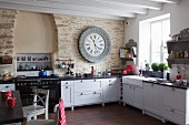 White country-house kitchen with large clock on stone wall