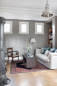 Pale couch and antique chair in wood-panelled room