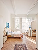 Bedroom with double bed, piano and herringbone parquet floor in modernised, Wilhelmine-era building
