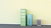 Three different filing cabinets against yellow polka-dot wallpaper