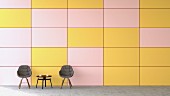 Waiting area with two chairs & coffee table against pink and yellow wall
