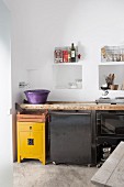 Rustic kitchen counter made from old wooden ladder below niches in wall