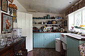 Pale blue wooden cupboards in old-fashioned kitchen