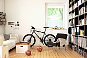 Bookcase, bicycles and old vaulting box used as coffee table in living room