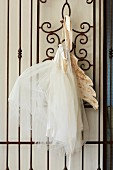 White tutu with wings hung on artistic wrought iron lattice