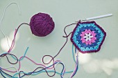 Crocheted floral hexagon in shades of blue and purple