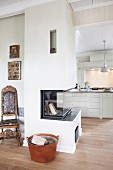 Modern fireplace in partition wall with country-house kitchen in background