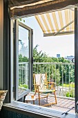 View of yellow folding chair on balcony seen through open window