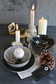 Decorative china bowls, silver owl and hand-painted gift labels in front of lit candles