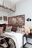 Bed decorated with vintage fabrics in a mixture of patterns