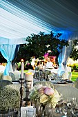 Festively set tables with candlelight atmosphere in white marquee