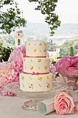 Multi tier wedding cake on glass pedestal cake stand