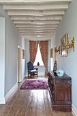 Schmaler Flur mit weiss lackierter restaurierter Holzbalkendecke, möbliert mit Stilmöbeln in eleganter Altbauwohnung