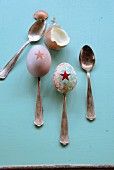 Easter eggs painted with star motifs on antique silver spoons