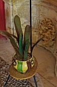 Plant-shaped ceramic artworks in pot on vintage plant stand
