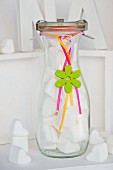 White marshmallow hearts in glass bottle decorated as gift