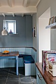 Rustic dining area in shades of blue with built-in bench and table with walnut top
