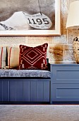 Patterned cushions on blue bench against stone wall