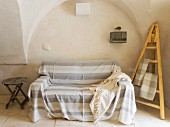 Striped throw on sofa and easel in Apulian trullo