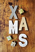 Rustic wooden letters spelling XMAS and tiny gift-box ornaments