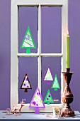 Christmas trees hand-crafted from paper in old window frame