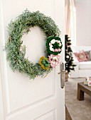 Hand-made wreath of wire, twigs and crocheted flowers on white interior door