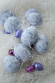 Painted Easter eggs and chocolate eggs amongst shredded paper