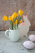 Crocuses in milk jug, Easter egg decorations and paper Easter bunnies