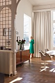 Woman in retro dining room with lead-glazed partition