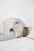 Clothes rail in arched niche in bedroom