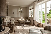 Light-flooded taupe interior with French windows, sofa and coffee table