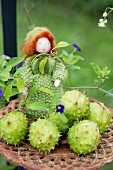Autumn arrangement of horse chestnuts in cases and felted wool doll on vintage trivet