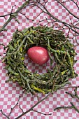 Stone egg in Easter nest of apple tree twigs