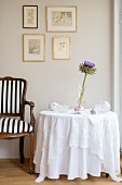 Baroque chair next to table with floor-length white tablecloth