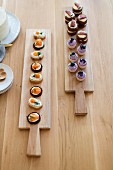 Various canapés on long wooden boards