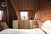 Bedroom with vaulted ceiling and modern wooden furniture in converted church
