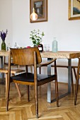 Rustic dining table and vintage chairs on herringbone parquet floor