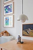 Pendant lamp above table and cat sitting on radiator