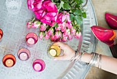Colourful Oriental tealight holders and bunch of roses on silver tray