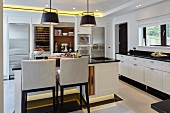Large black and white kitchen with island counter, recessed ceiling spotlights and plinth lights