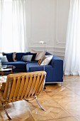 Sitzecke mit blauem Sofa und Ledersessel in Altbauwohnung