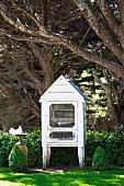 Pigeon house under trees, white pigeon at the bird bath