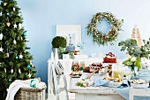 Weihnachtstisch mit Kuchen und Keksen neben dem Christbaum