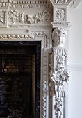 Detail of fireplace with ornate stucco elements and bust