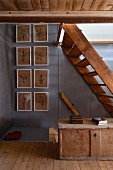 Old wooden stairs, wooden trunk and floral pictures in rustic hallway